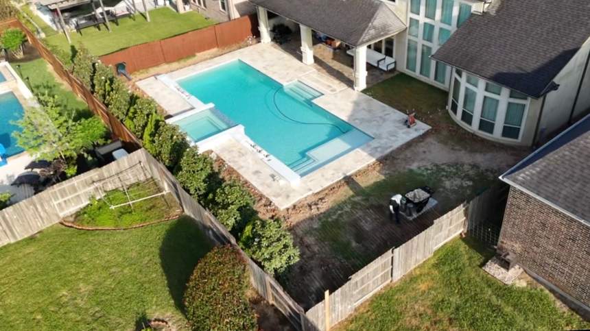 Aerial view of a backyard and pool before turf installation